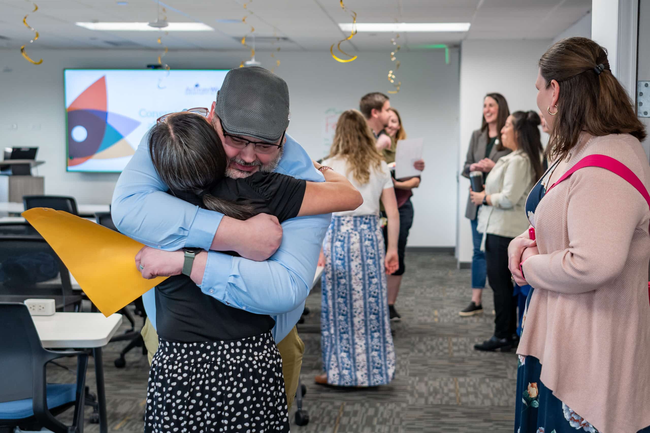 Fred Delehoy hugging his career coach, Kelli Turner, at his cohort's graduation