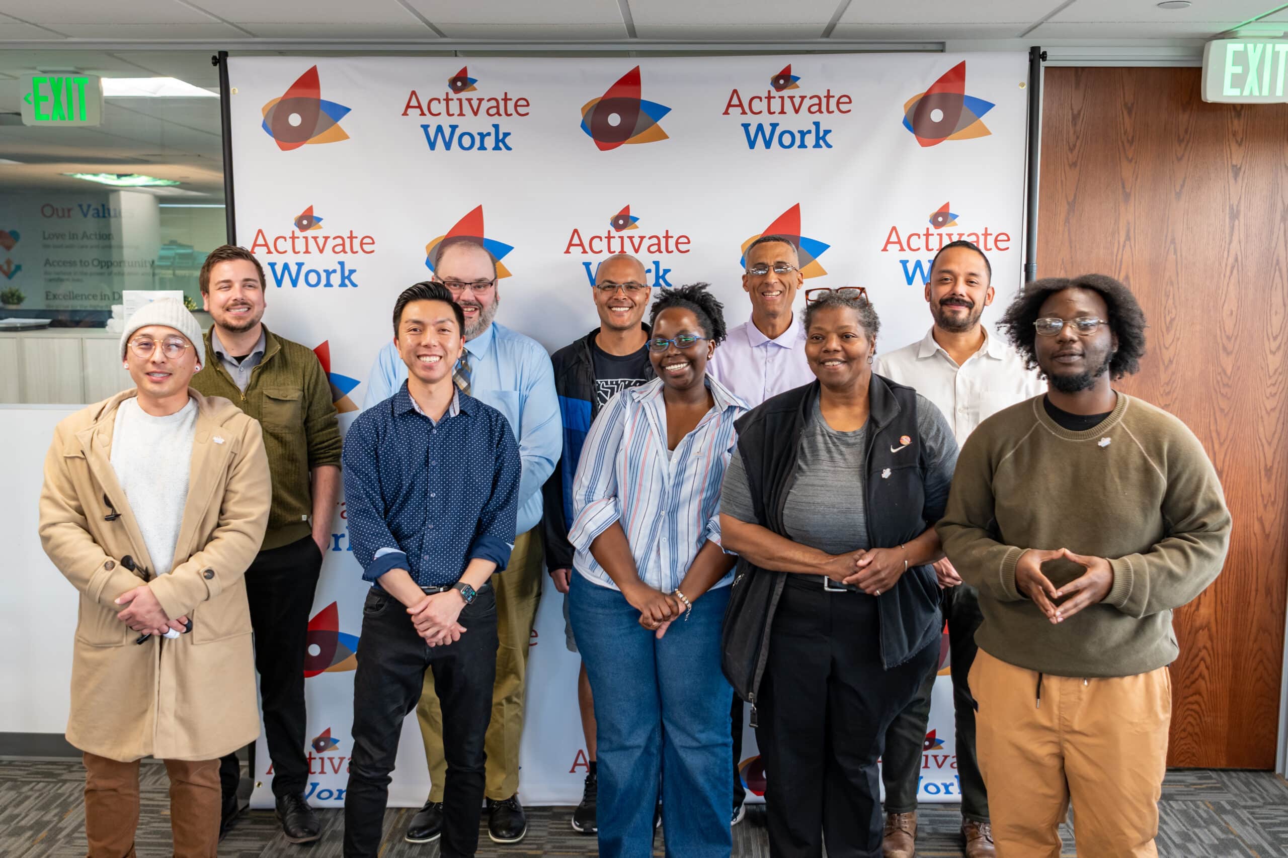 A group photo of the ITSF 2025-DEN-06 cohort at their graduation, smiling in front of an ActivateWork backdrop.