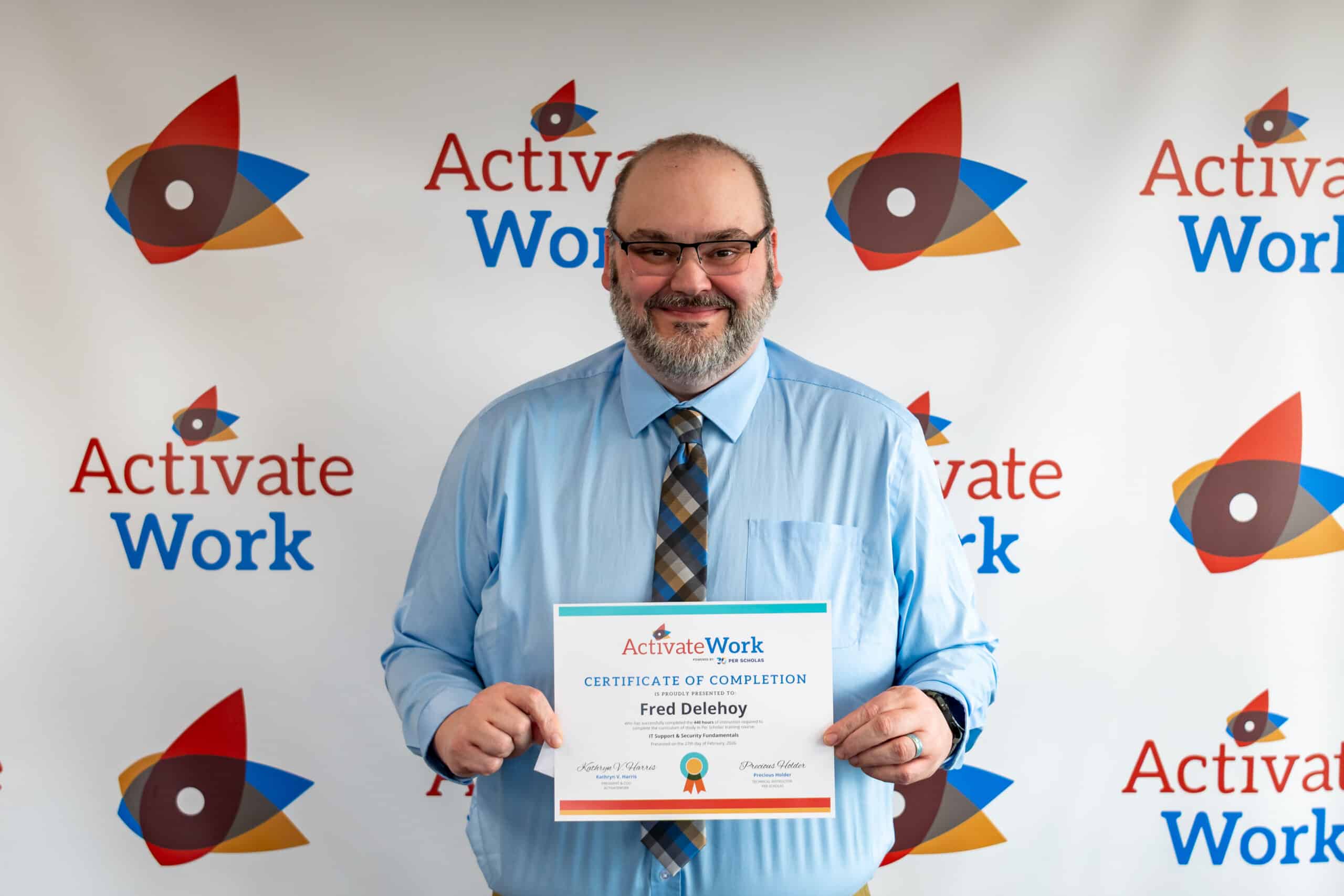 Fred Delehoy holding his certificate of completion at graduation