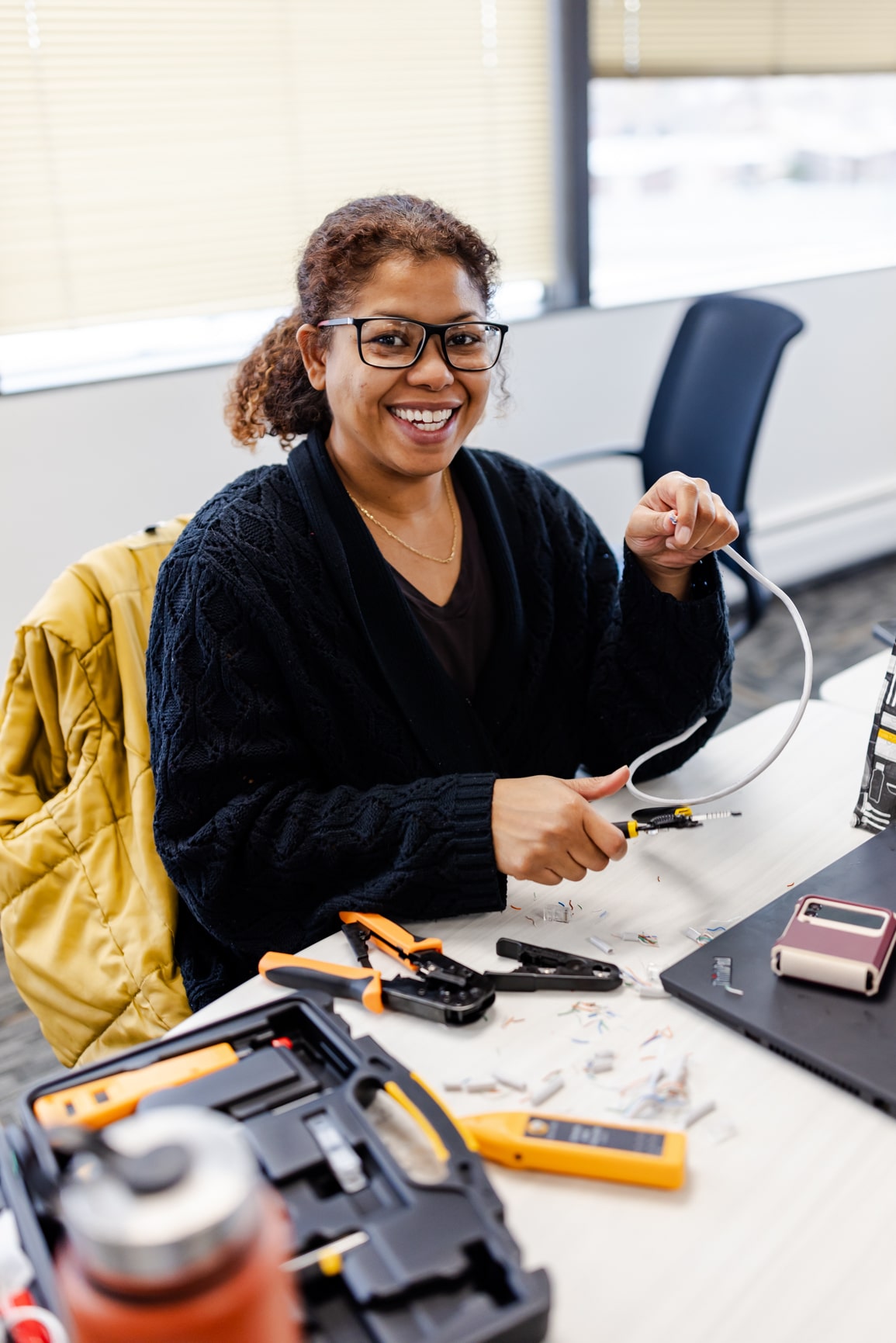 An ActivateWork learner working with cables and pliers during a classroom lab