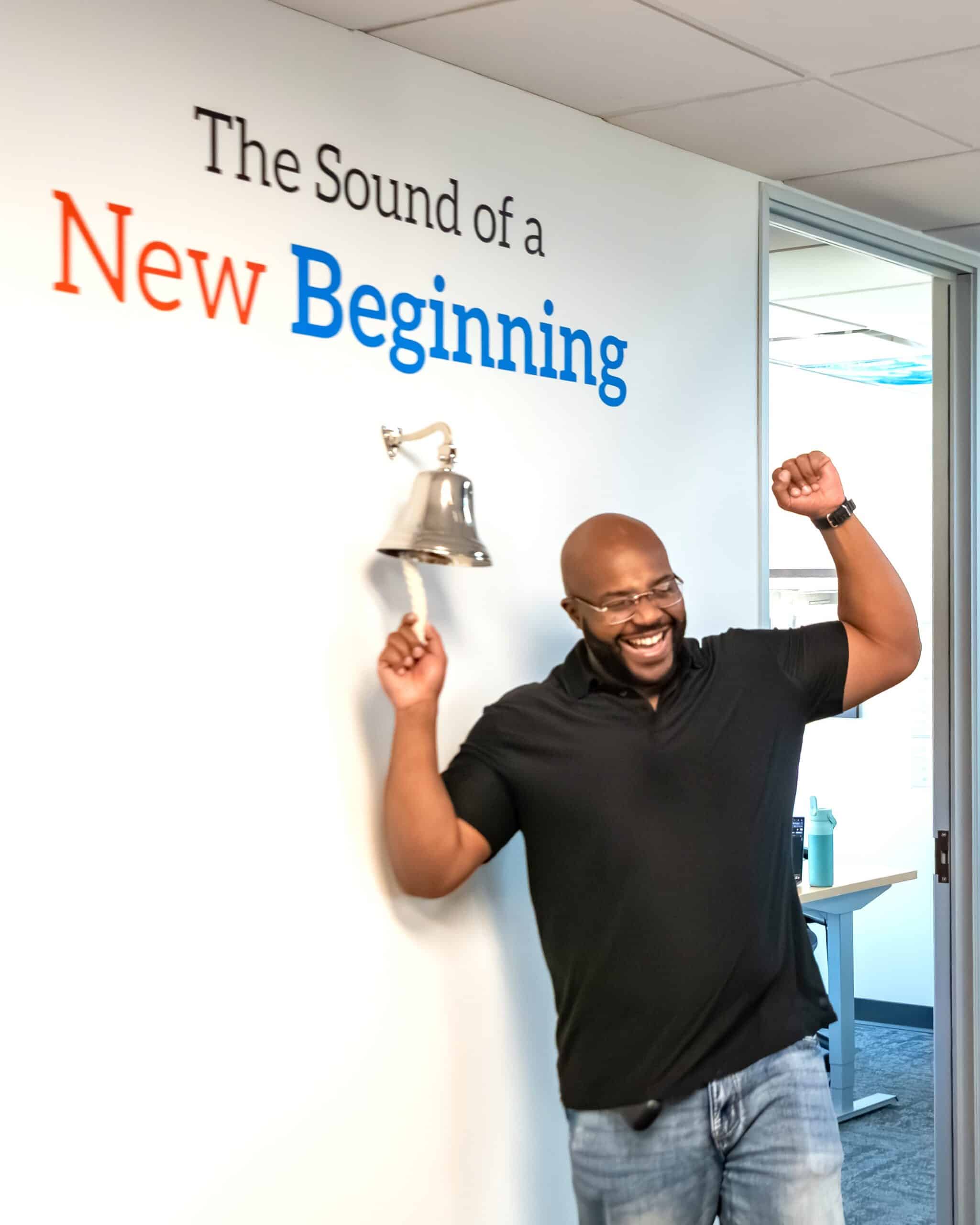 An ActivateWork graduate ringing the bell for his new job placement