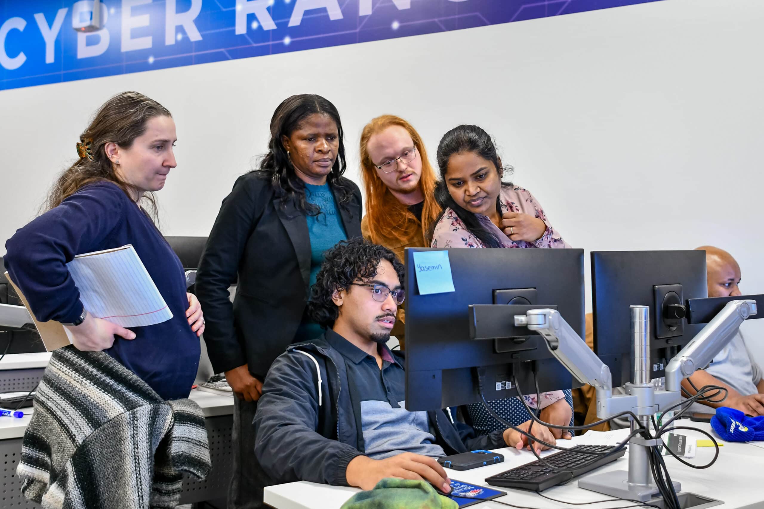 Toa and team working to respond to a simulated cyber attack during their capstone experience at MSU Denver's Cybersecurity Center.