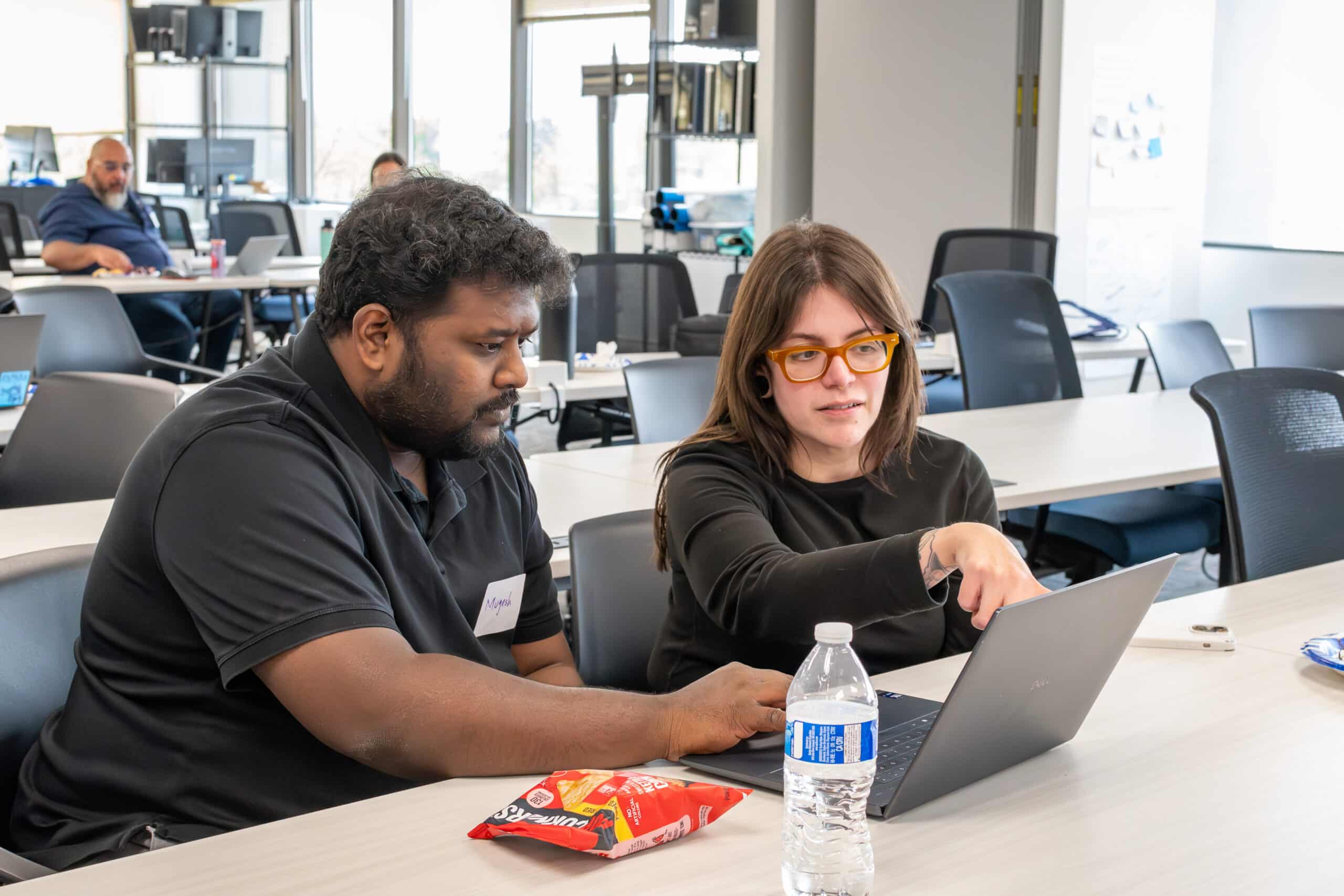 An ActivateWork coach helps a learner polish his resume during an Alumni Job Search Party.