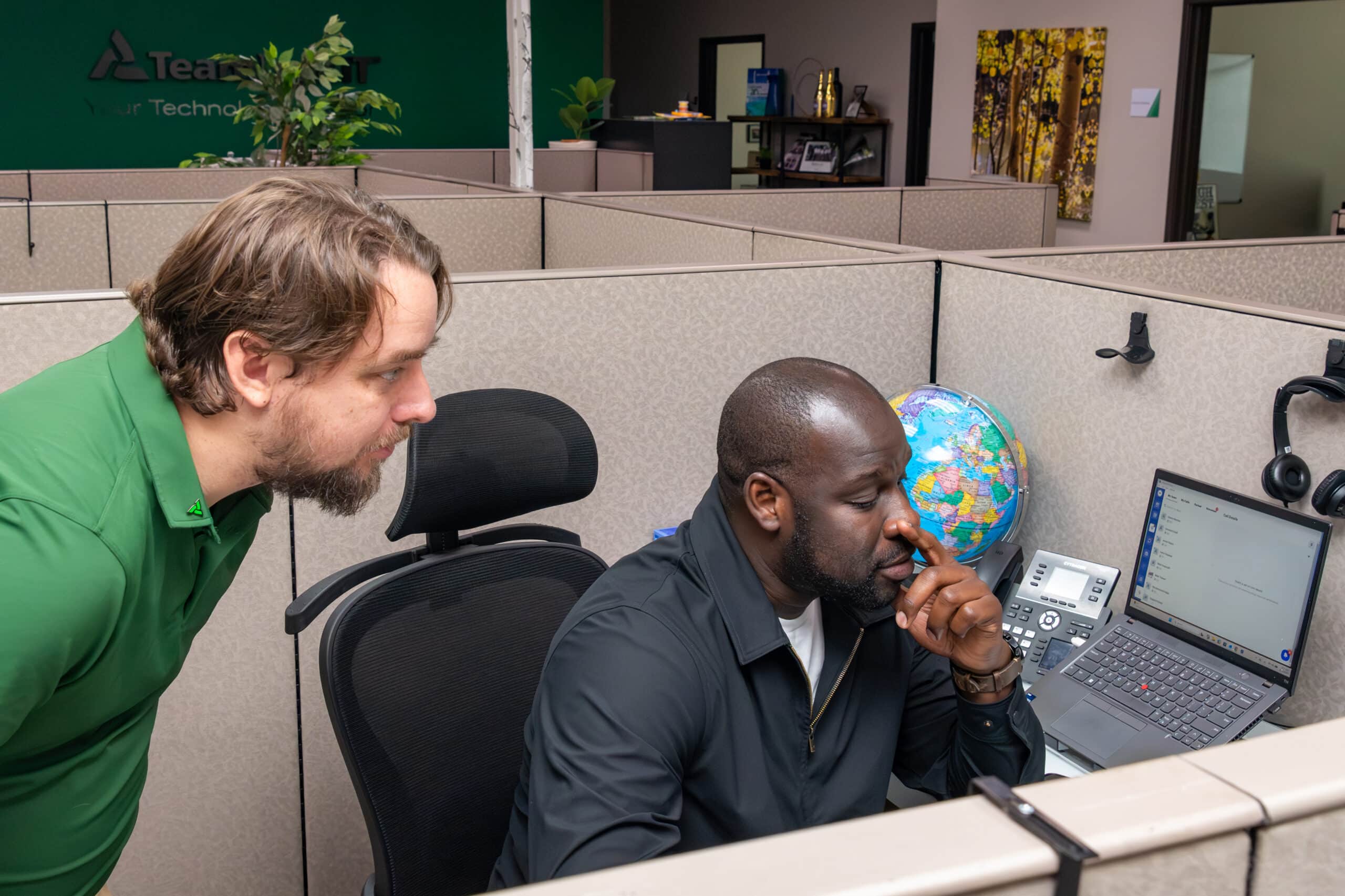 TeamLogic IT CTO Danny Ramey reviews the docket of open tickets with Apprentice Mouhamad Gaye.